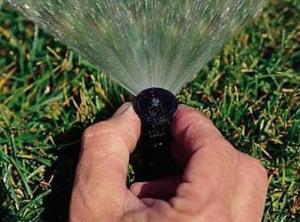 a sprinkler head being adjusted by a Santa Cruz Irrigtion Repair specialist